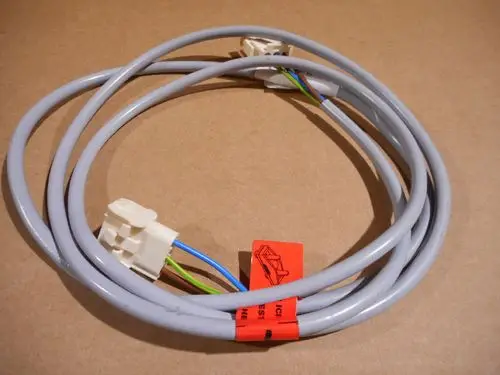 Remeha Kabel mit weißen Steckverbindern und mehreren farbigen Drähten, auf einem neutralen Hintergrund liegend.